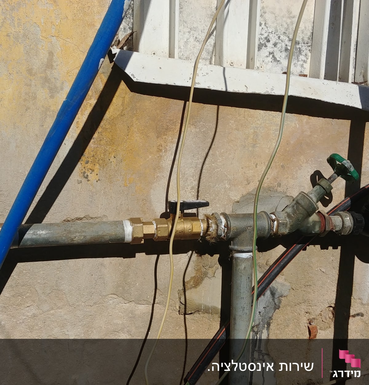 צינורות מים עם ברזים על קיר חיצוני